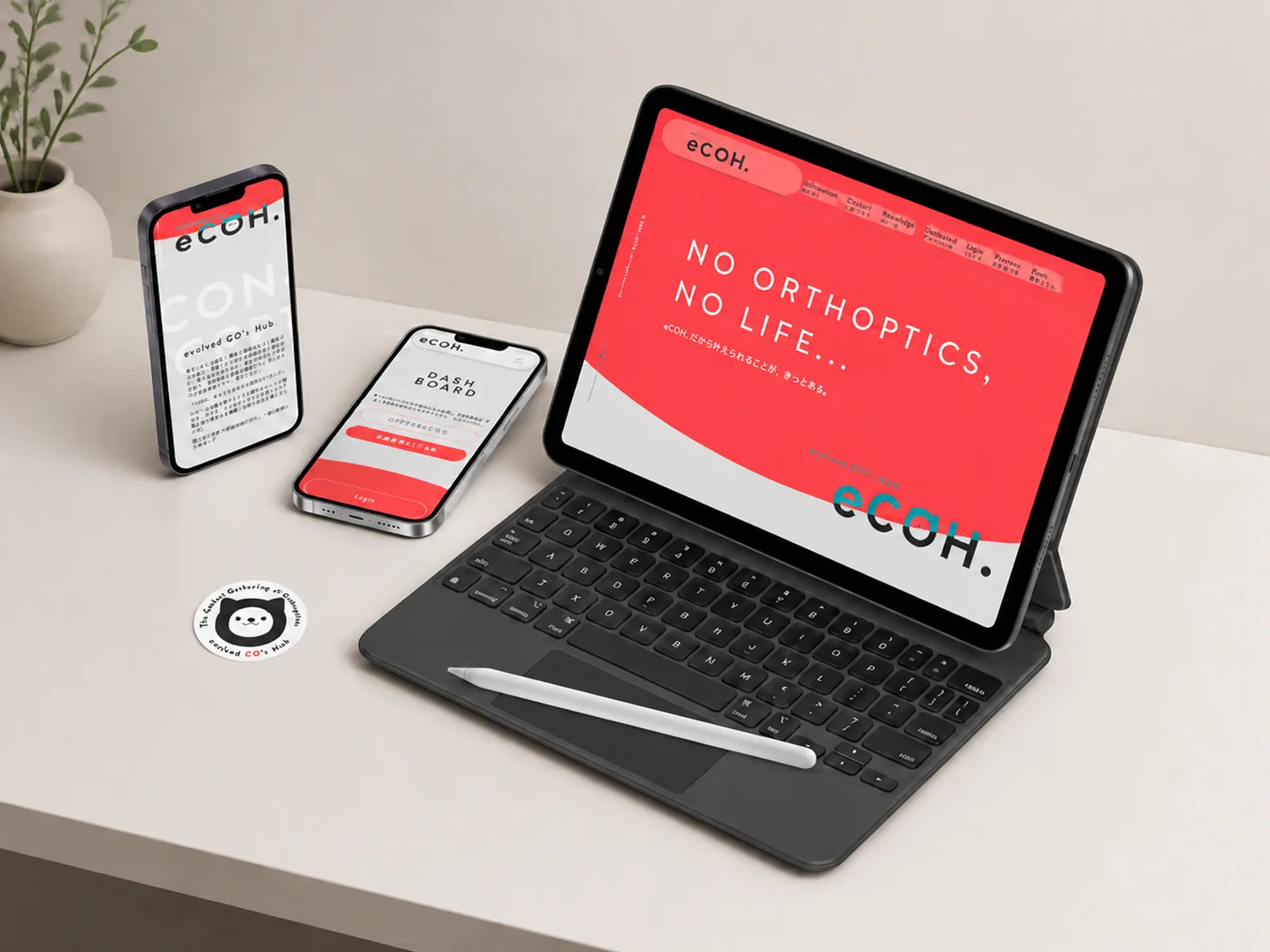 eCOH.（視能訓練士コミュニティ）のブランディング：iPad・iPhone・マスコットステッカーを並べたデスクシーン